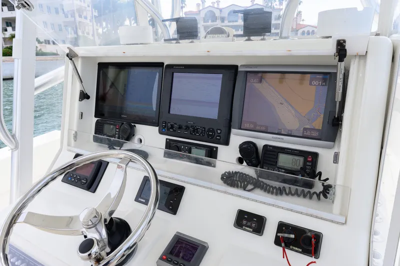 Slide: The Image of Control panel of a 2011 SeaVee 340B Open boat with navigation screens and steering wheel. - 7