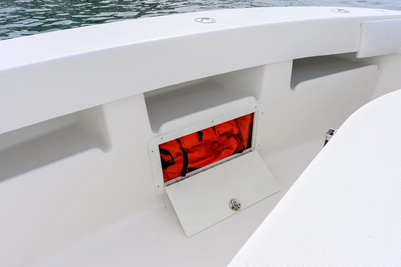 Slide: The Image of 2011 SeaVee 340B Open boat storage compartment with orange life jackets. - 15