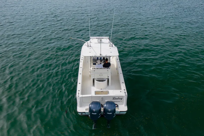 Slide: The Image of 2011 SeaVee 340B Open boat on calm water, rear view with dual engines. - 2