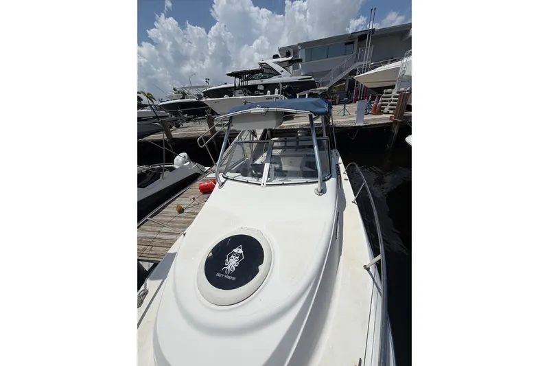 Slide: The Image of 2002 Sea Fox 230 Walk Around boat docked at marina under cloudy sky. - 30