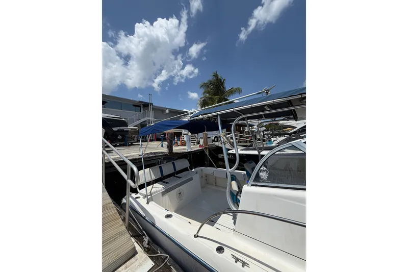 The Image of 2002 Sea Fox 230 Walk Around boat docked under a clear blue sky. - 2