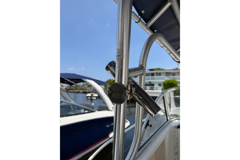 Slide: The Image of Close-up of a 2002 Sea Fox 230 Walk Around boat's metal railing and rod holder. - 26
