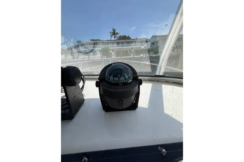 Slide: The Image of Compass on 2002 Sea Fox 230 Walk Around boat dashboard, with clear sky background. - 21