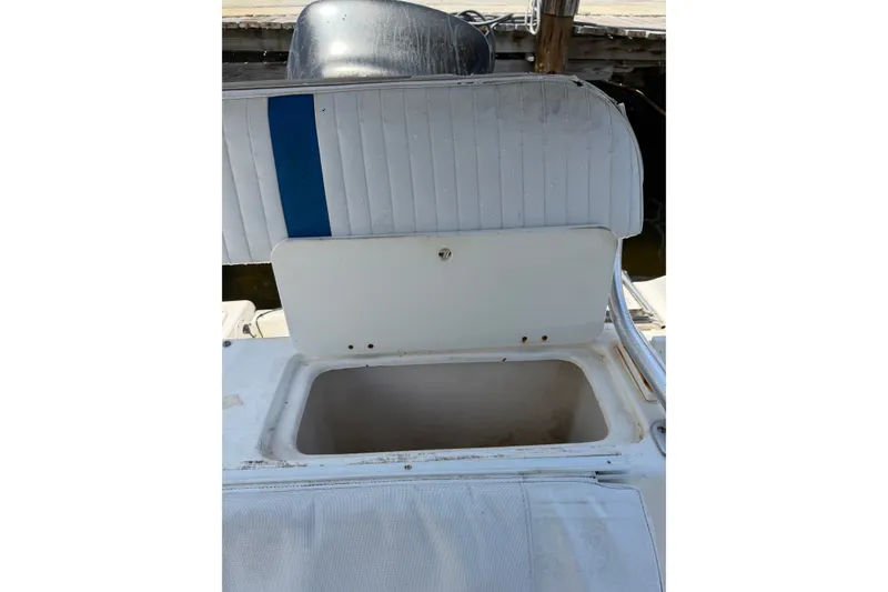 Slide: The Image of 2002 Sea Fox 230 Walk Around boat seat with open storage compartment. - 35