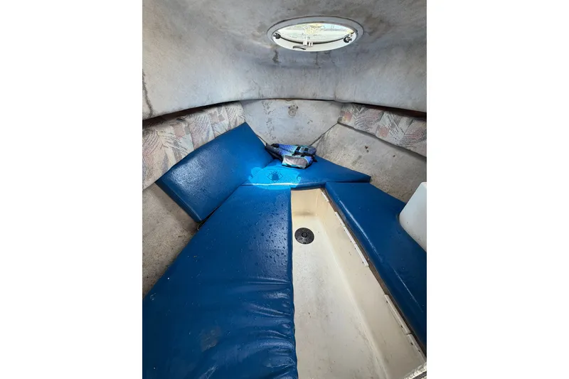 Slide: The Image of Interior cabin of 2002 Sea Fox 230 Walk Around boat with blue cushions. - 22