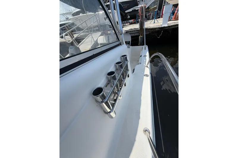 Slide: The Image of 2002 Sea Fox 230 Walk Around boat with rod holders, docked at marina. - 31