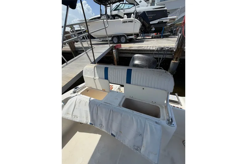 Slide: The Image of 2002 Sea Fox 230 Walk Around boat with open storage compartment at dockside. - 39