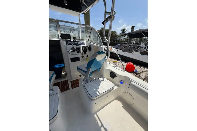 Slide: The Image of 2002 Sea Fox 230 Walk Around boat interior with steering wheel and seating. - 15