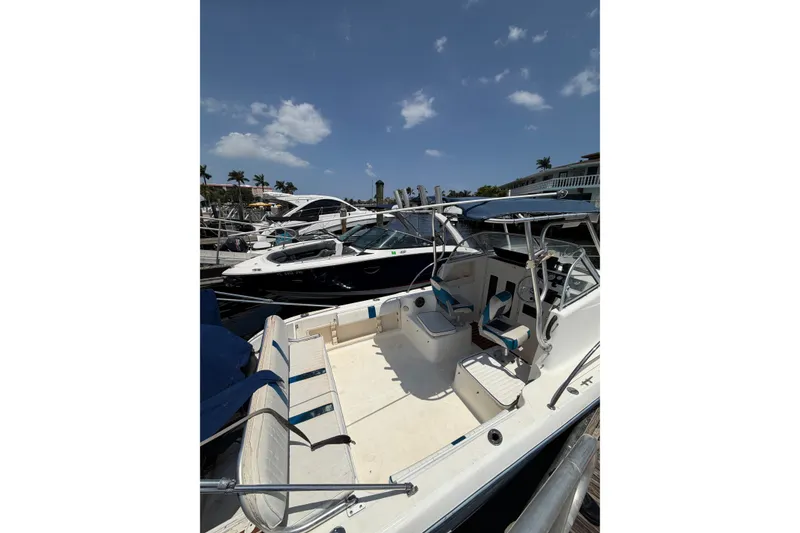 Slide: The Image of 2002 Sea Fox 230 Walk Around boat docked under a clear blue sky. - 10