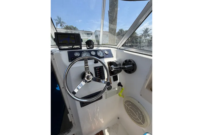 Slide: The Image of Steering console of a 2002 Sea Fox 230 Walk Around boat with navigation equipment. - 16