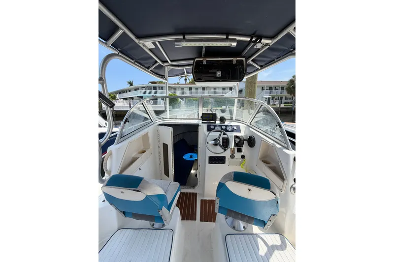 Slide: The Image of Interior view of a 2002 Sea Fox 230 Walk Around boat, featuring helm and seating. - 25
