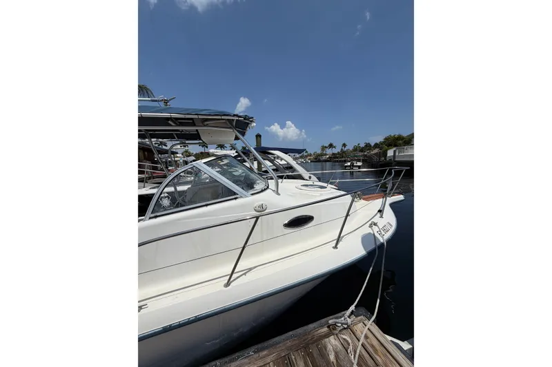Slide: The Image of 2002 Sea Fox 230 Walk Around boat docked under clear blue sky. - 1