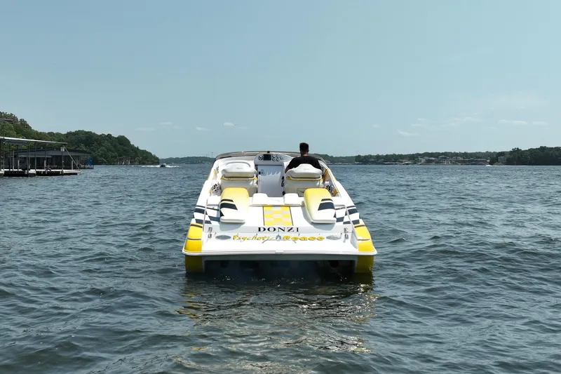 Slide: The Image of 2002 Donzi 38 Daytona speedboat cruising on a sunny lake. - 4