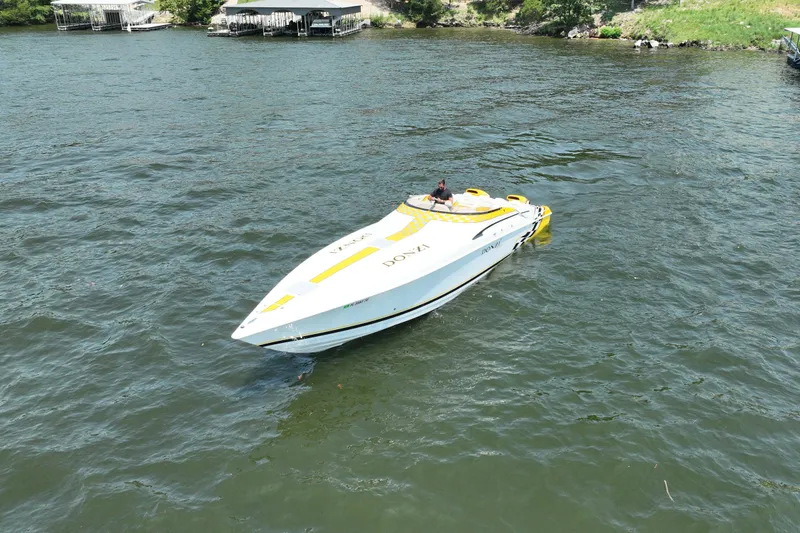 Slide: The Image of 2002 Donzi 38 Daytona speedboat cruising on a lake, featuring a sleek yellow and white design. - 9