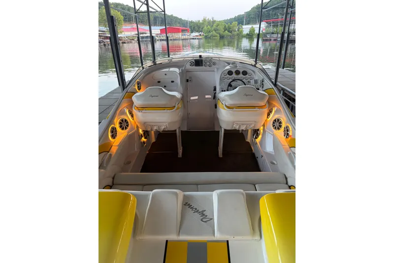 Slide: The Image of 2002 Donzi 38 Daytona boat interior with illuminated dashboard and seating at a marina. - 19