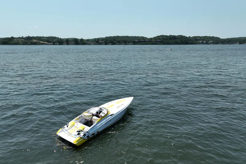 Slide: The Image of 2002 Donzi 38 Daytona speedboat on a calm lake with distant shoreline. - 25