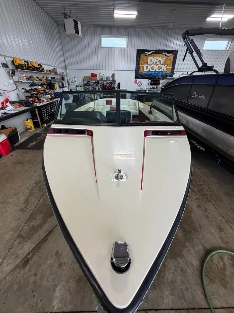 Slide: The Image of A 1987 Correct Craft Ski Nautique 2001 boat in a workshop. It features a white deck and windshield. - 21