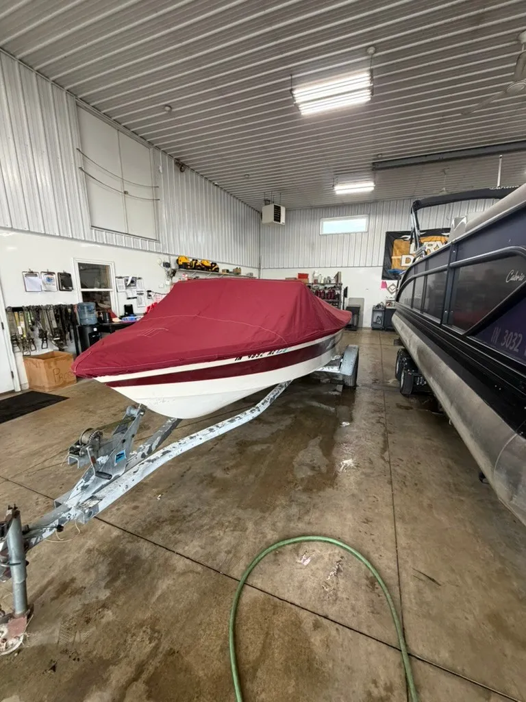 Slide: The Image of A 1987 Correct Craft Ski Nautique 2001 is in a garage on a trailer, covered with a red tarp. - 29