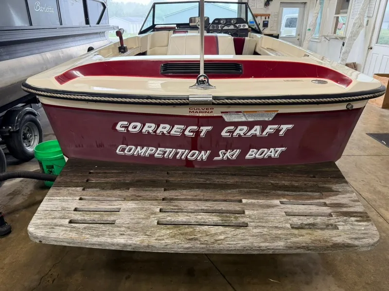 Slide: The Image of A red 1987 Correct Craft Ski Nautique 2001 in a garage. It features a wooden platform. - 16