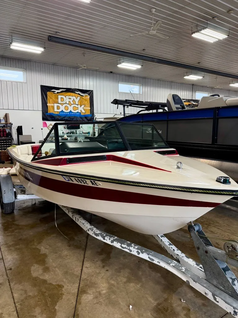 The Image of A 1987 Correct Craft Ski Nautique 2001 boat on a trailer inside a warehouse. - 1