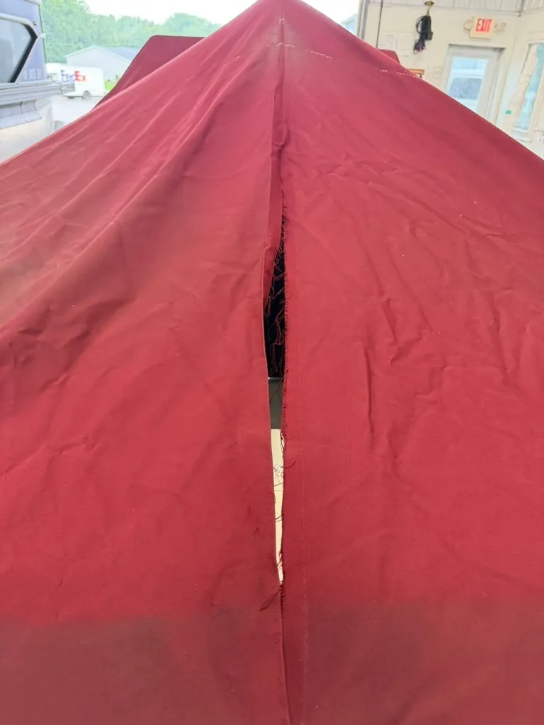 Slide: The Image of A red boat cover with a tear in the middle, situated in a garage. - 23