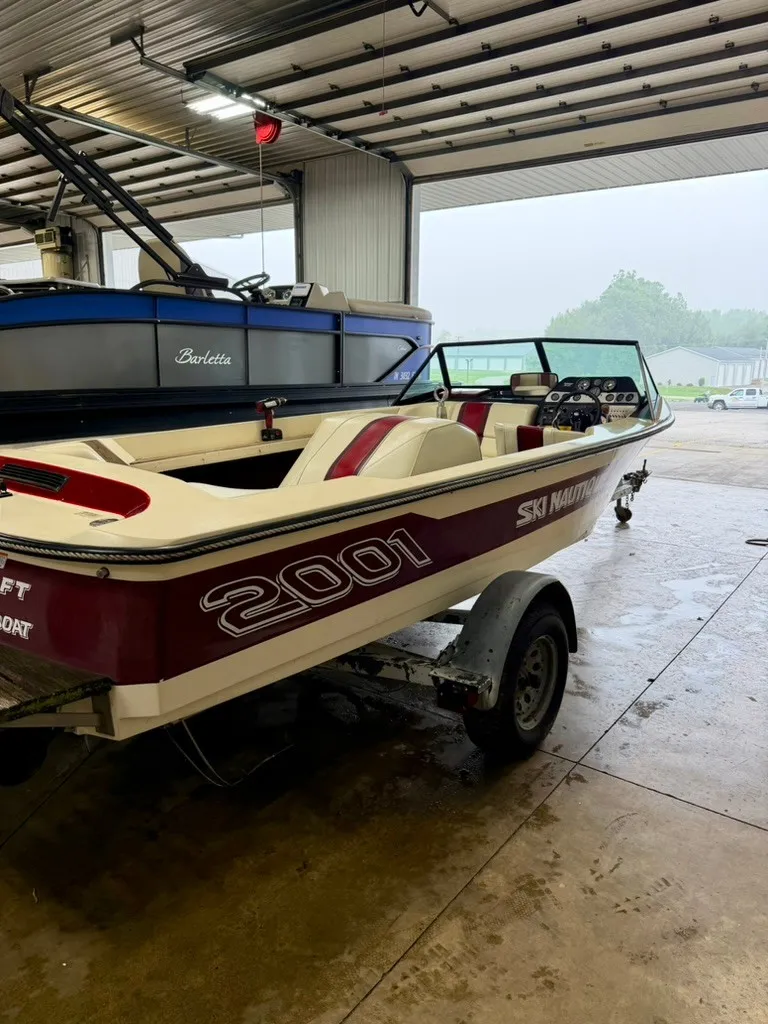 Slide: The Image of A 1987 Correct Craft Ski Nautique 2001 boat in a garage. It features red and white accents. - 19