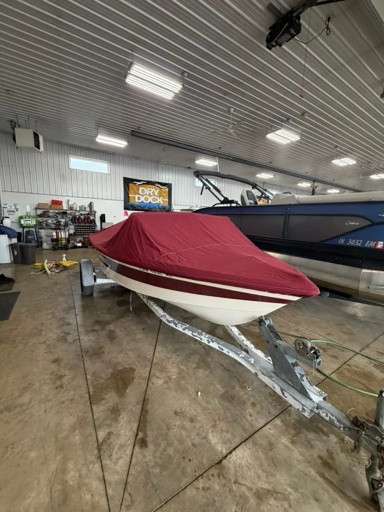 Slide: The Image of A 1987 Correct Craft Ski Nautique 2001 is on a trailer in a warehouse. The boat is covered with a red tarp. - 28