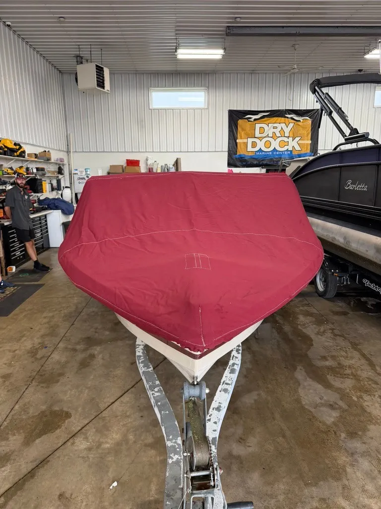 Slide: The Image of A 1987 Correct Craft Ski Nautique 2001 covered with a red tarp in a workshop. - 27