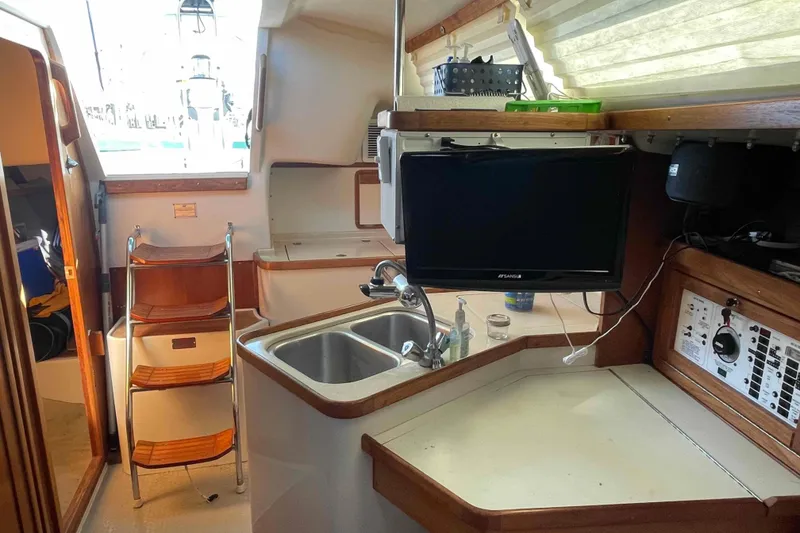 Slide: The Image of Interior of a Catalina 320 sailboat with kitchen and navigation area. - 93