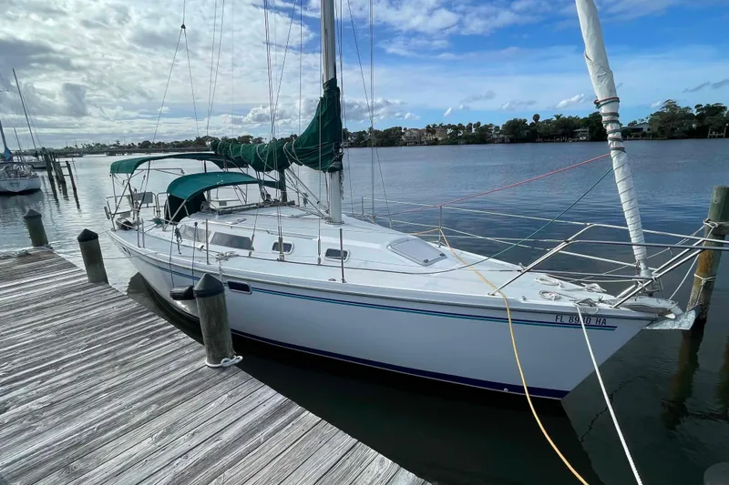 Slide: The Image of Catalina 320 sailboat docked at a marina under a partly cloudy sky. - 72
