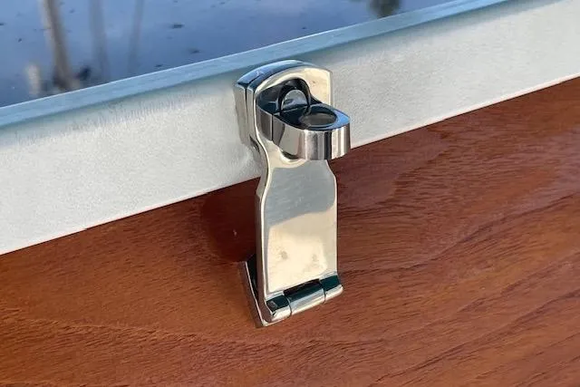 Slide: The Image of Stainless steel latch on Catalina 320 boat, 1995 model, against wooden surface. - 81