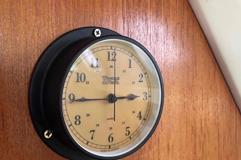 Slide: The Image of Wheems & Plath Analog clock on wooden panel inside a Catalina 320 boat cabin. - 110