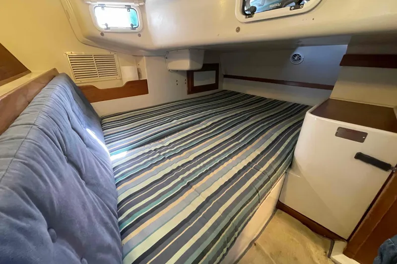 Slide: The Image of Cozy cabin interior of 1995 Catalina 320 sailboat with striped bedding and porthole window. - 15