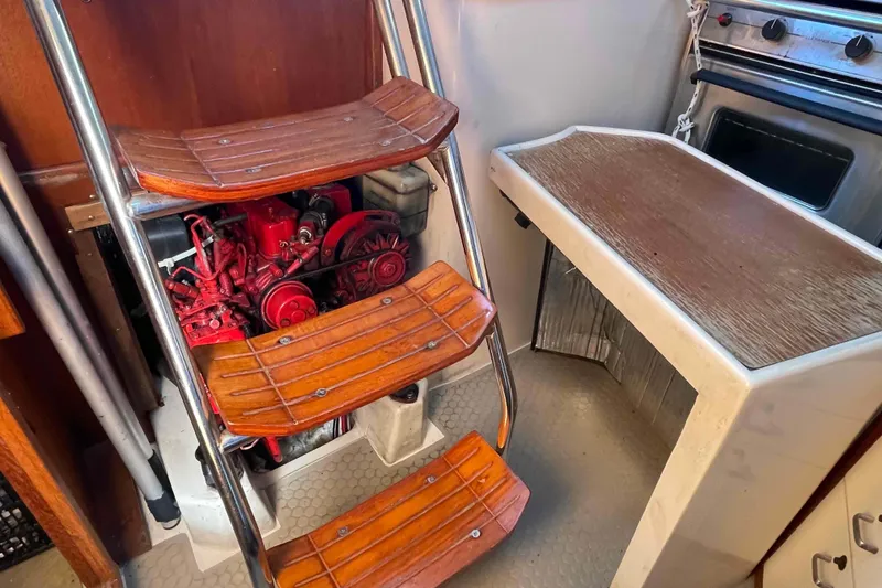Slide: The Image of Engine compartment of a Catalina 320 sailboat with wooden steps and adjacent stove. - 27