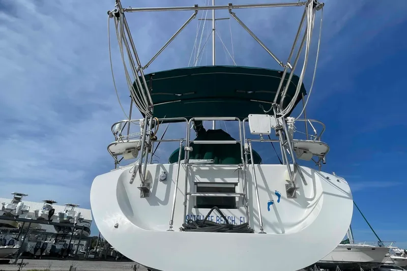 Slide: The Image of Catalina 320 sailboat with green canopy, docked under a clear blue sky. - 47