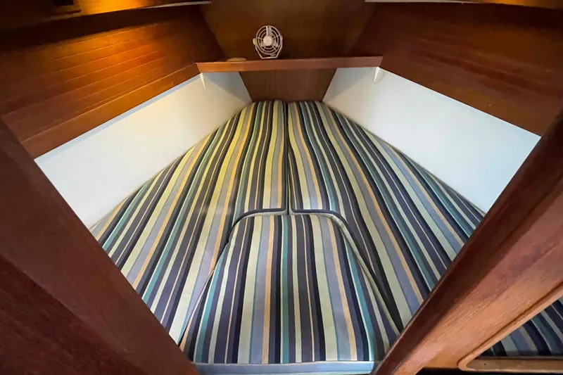 Slide: The Image of Cozy cabin interior of a Catalina 320 sailboat with striped bedding. - 101