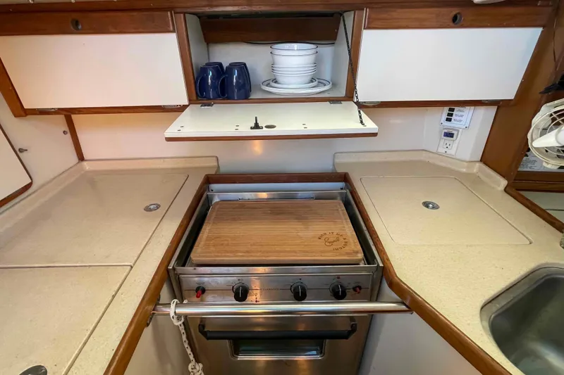 Slide: The Image of Compact kitchen in a Catalina 320 sailboat with stove, sink, and storage. - 22
