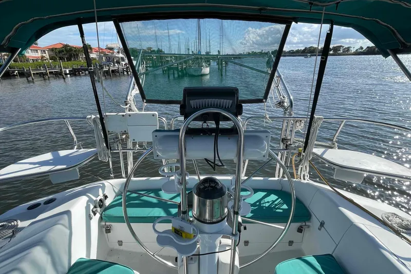 Slide: The Image of Cockpit view of a Catalina 320 sailboat with teal seating and marina backdrop. - 89