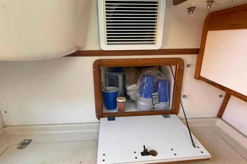 Slide: The Image of Interior storage of 1995 Catalina 320 sailboat with cups and supplies. - 21