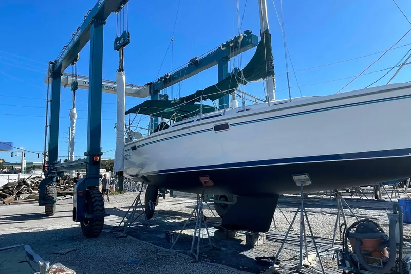 Slide: The Image of Sailboat Catalina 320 on stands in a boatyard under a clear blue sky. - 45