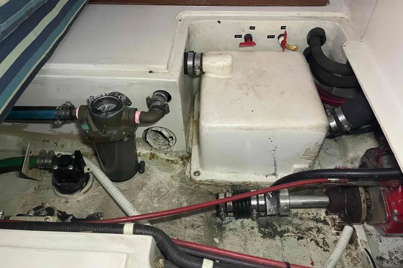 Slide: The Image of Engine compartment of a 1995 Catalina 320 sailboat, showing mechanical components and hoses. - 33
