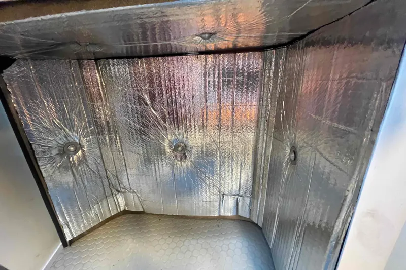 Slide: The Image of Insulated compartment of a Catalina 320 sailboat, featuring sound down reflective foil w/lead lining.  Keeps heat and sound down. - 30