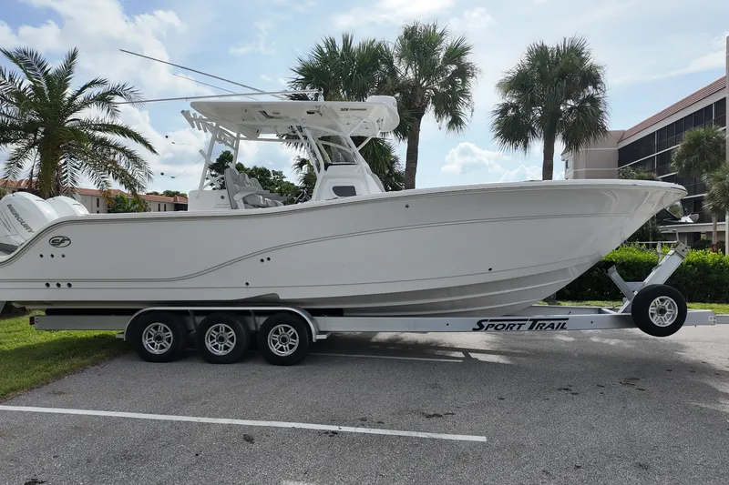 Slide: The Image of 2023 Sea Fox 328 Commander boat on trailer, parked near palm trees. - 3