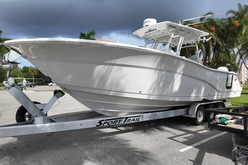 Slide: The Image of 2023 Sea Fox 328 Commander boat on trailer, parked under cloudy sky. - 2