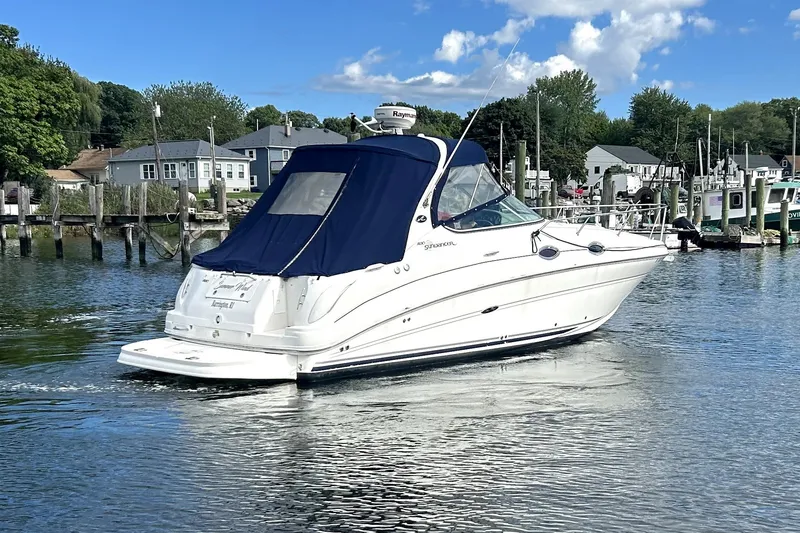 Slide: The Image of 2006 Sea Ray Sundancer 280 cruising on a calm waterway near a marina. - 8