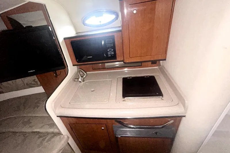Slide: The Image of 2006 Sea Ray Sundancer 280 interior kitchen with microwave, sink, and stove. - 18