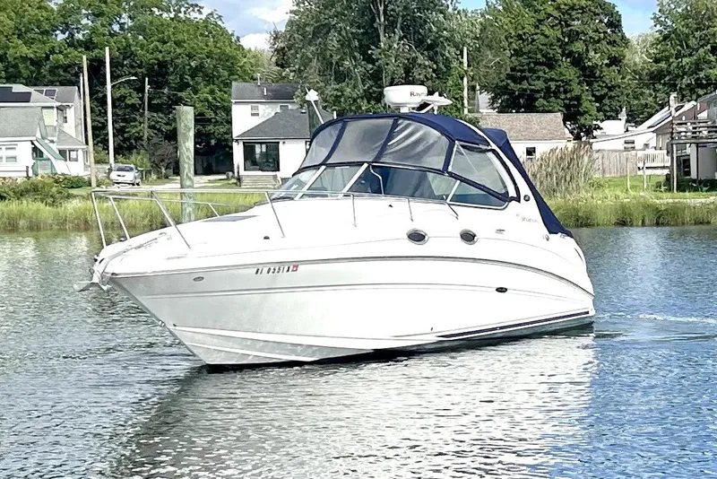 Slide: The Image of 2006 Sea Ray Sundancer 280 cruising on a calm river near residential area. - 2