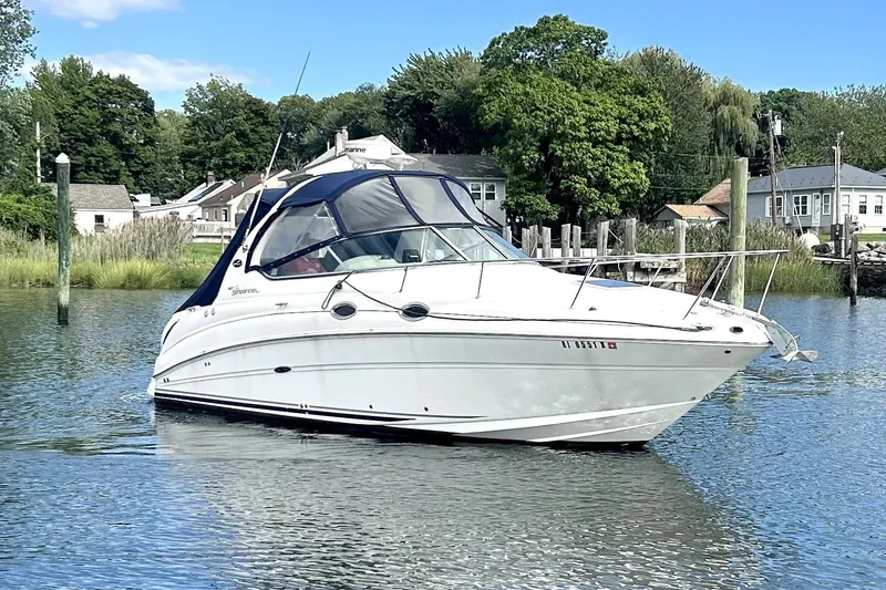 Slide: The Image of 2006 Sea Ray Sundancer 280 boat on calm water, surrounded by greenery and houses. - 5