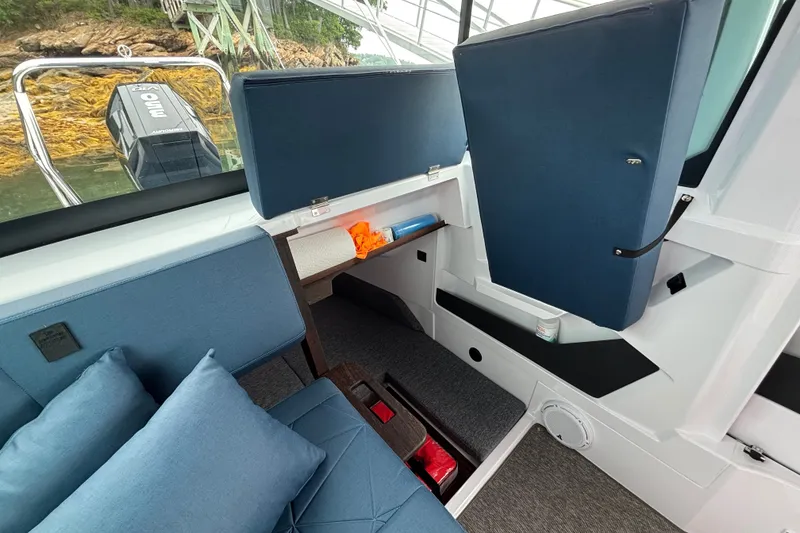 Slide: The Image of Interior of 2025 Axopar 29 XC Cross Cabin with blue seating and storage compartments. - 32