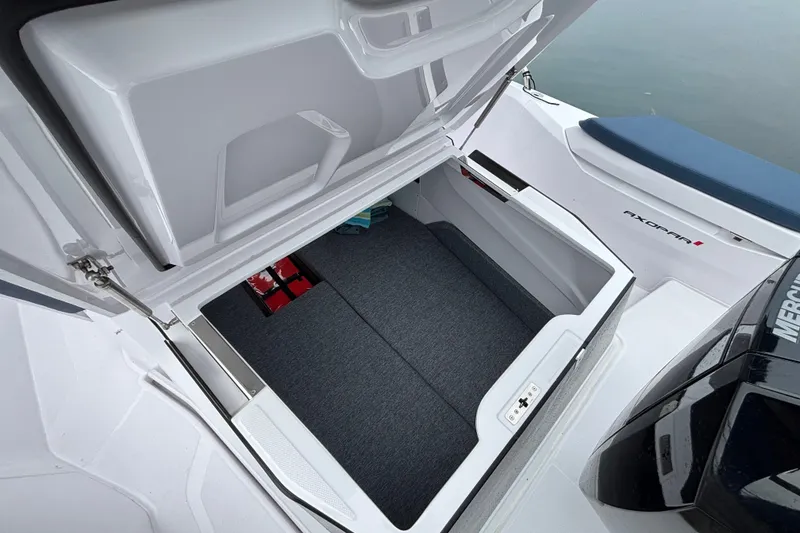 Slide: The Image of 2025 Axopar 29 XC Cross Cabin storage compartment with open lid, showcasing spacious interior. - 42